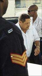 Rodney Chin, one of three persons charged in connection with the Cuban light-bulb programme, makes his way from a police service vehicle to the holding area of the Corporate Area Resident Magistrate's Court, Half-Way Tree, St Andrew, on February 27, 2008. - Rudolph Brown/Chief Photographer. cuban1