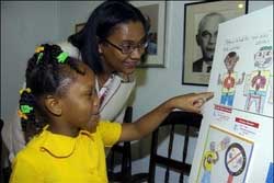 Judy Benjamin, sales manager at Jamaica National Building Society (JNBS), admires the winning entry in the Jamaica Cancer Society's Anti-Tobacco Smoking Poster Competition, which belongs to six-year-old Alyesha Taylor Coleman of the Mineral Heights Christian Kinder-Prep School. Ten students from grades one and five were awarded with Easi-Save Accounts from JNBS for their entries in the poster competition last June. - Contributed. littlegrl
