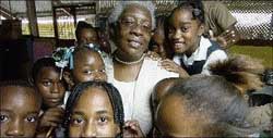 Lizette Morrison, principal of the Tulloch Primary School in Bog Walk, St Catherine, is surrounded by her grade five students at the institution yesterday. - Ricardo Makyn/Staff Photographer lizettemorrison