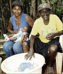 Seventy-eight-year-old Matilda Morant (right) sits beside her granddaughter Bobbeth Powell and Powell's two-month-old baby, both of whom she delivered in Harmons, a community in Manchester. - Norman Grindley/Chief Photographer. matildamorant
