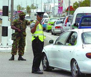 chaos: A police officer directs traffic onto the east-bound lane of the Churchill-Roosevelt Highway at the Macoya Intersection in Tunapuna yesterday. The lane was operated as a dual carriageway and the west-bound lane was closed during Exercise Footprint, which was conducted in preparation for the Fifth Summit of the Americas. policecontroltrini