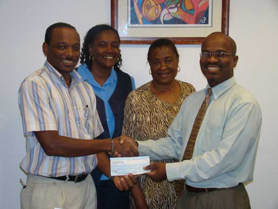 Steven Patrick presents the cheque to VP Rolando Tobias, while other JFE members look on. littleswitz